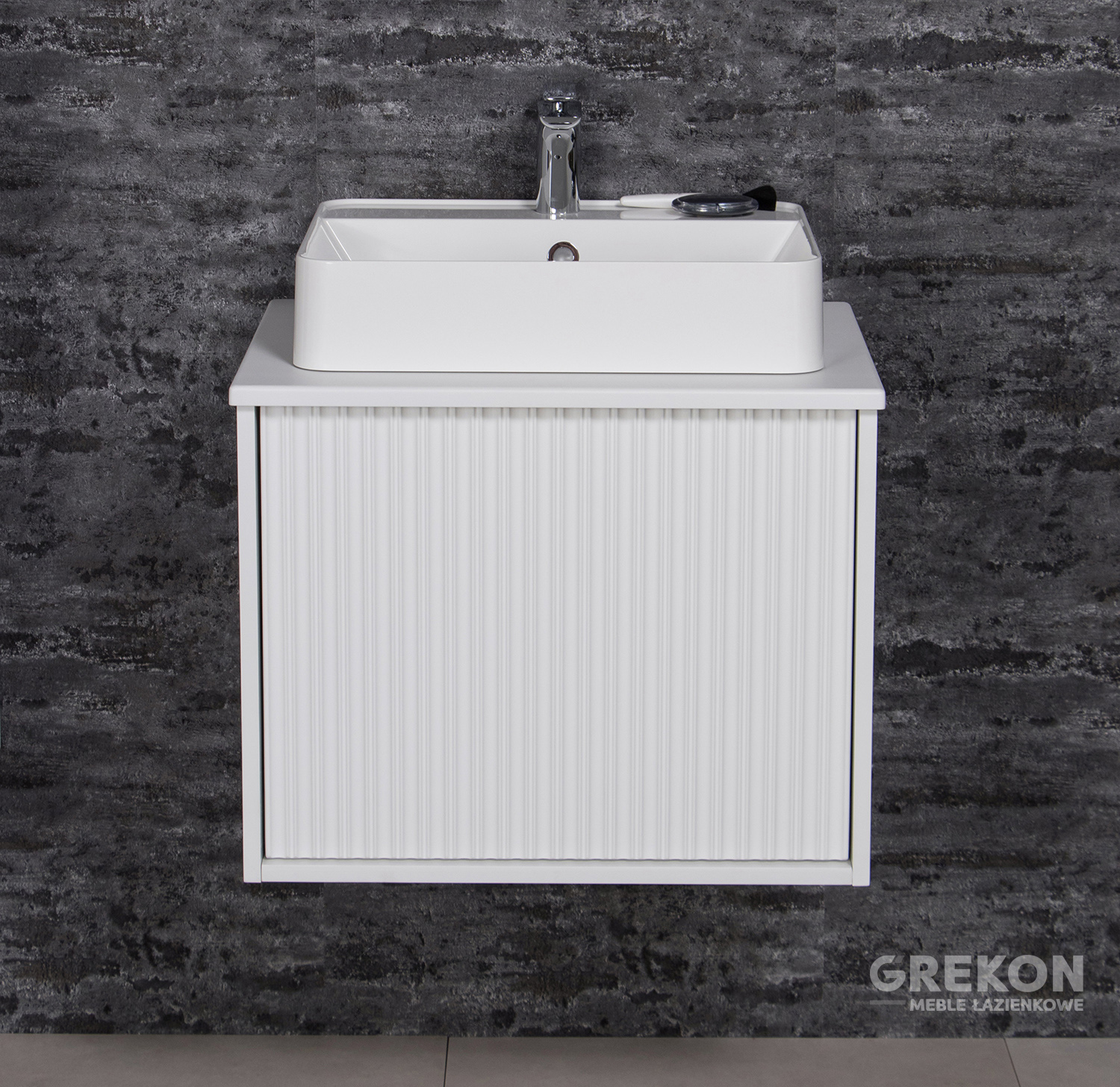 


Valge vannitoakapp töötasapinna ja valge töötasapinna valamuga. Matte esikülgi kaunistab moodne 3D-struktuur vertikaalsete, sümmeetriliste paneelide kujul, m